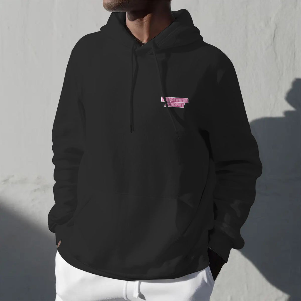 Person wearing a black hoodie with a pink logo against a gray wall